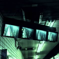 an overhead view of a hallway with multiple screens on the wall and lights in the ceiling