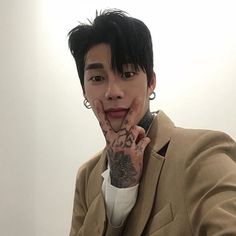 a man with black hair and tattoos on his hand