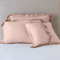 three pillows sitting on top of a bed next to each other