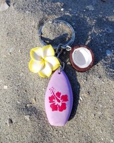 Hawaiian style summer fashion. Surfboard shaped keychain or beach bag charm, adorned with two yellow and white plumeria flower charms and a half coconut. The surfboard is made from lavender colored clay and decorated with a dark pink hibiscus. Perfect gift for surf and beach lovers of all ages. APPROXIMATE MEASUREMENTS: Total length: 8 cm (around 3,15" inches) Surf: 3 x 1.8 x 0.8 cm (1,18" x 0,71" x0,31" inches) Flower: 2 x 2 x 1 cm (0,79" x 0,79" x 0,39" inches) Coconut: 1.5 x 1.5 x 0.7 cm (0,5 Hibiscus Flower Keychain, Clay Summer Ideas, Surf Board Ideas, Coconut Girl Accessories, Coconut Girl Wishlist, Summer Things To Buy, Summer Clay Ideas, Surf Boards Aesthetic, Surf Keychain