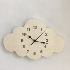 a clock that is on the side of a wall with numbers and clouds around it