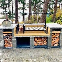 an outdoor grill made out of firewood in the woods