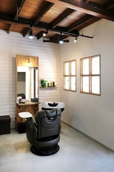 a hair salon with white walls and wooden beams on the ceiling is shown in this image