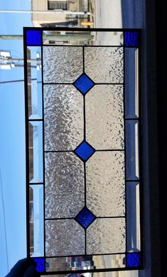 a close up of a stained glass window with blue and white designs on it's side