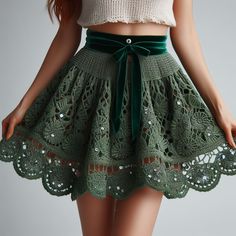 a close up of a woman wearing a skirt with lace on the bottom and green belt