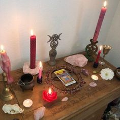 a table topped with candles and other items on top of it's wooden surface