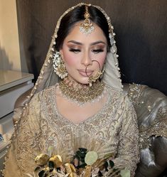 a woman in a bridal gown with her nose ring and headpieces on