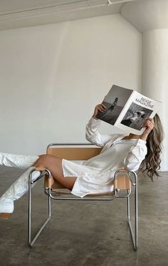 a woman sitting in a chair reading a book