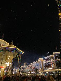 a crowd of people standing in front of a building with lights and decorations on it