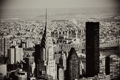 black and white photograph of new york city from the top of empire building, looking down on manhattan