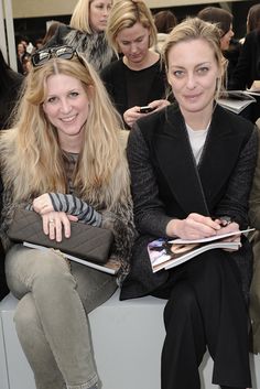 two women sitting next to each other at a fashion show