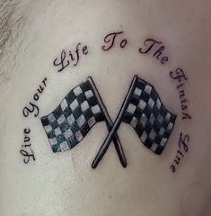 a man's chest with two crossed checkered flags and the words life to the finish