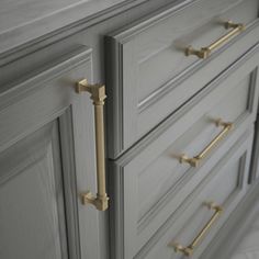 an image of a gray dresser with brass handles