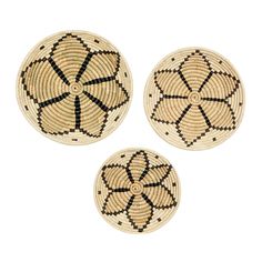 three woven baskets with black and white designs on the bottom, one has an arrow in it