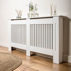 a white radiator sitting on top of a wooden floor next to a rug