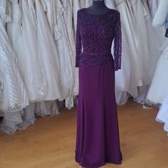 a purple dress on display in front of wedding gowns