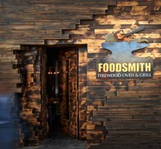 there is a sign that says foodsmith firewood oven and grill on the wall