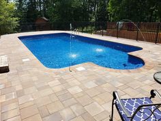 an empty swimming pool surrounded by patio furniture