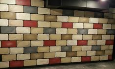 a brick wall with red, grey and white tiles on it in a restaurant or bar