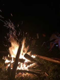 people sitting around a campfire at night