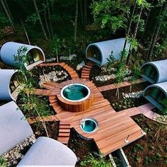 an aerial view of a hot tub in the middle of a forest with benches around it