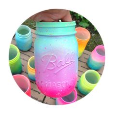 a hand holding a mason jar filled with different colored plastic cups and the words diy written on it