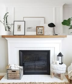 a living room with a fireplace and pictures on the mantle