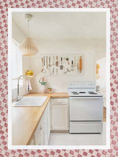 a white stove top oven sitting inside of a kitchen next to a sink and counter