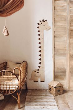 a wooden giraffe hanging on the wall next to a wicker chair and basket