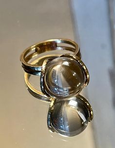 Rare 14k BRUTALIST MODERNIST POOLS OF LIGHT ROCK CRYSTAL GLASS ORB Ring!  in excellent condition! arrives in jewelry case and can be gifted immediately! crafted in solid 14k yellow gold - hallmarked and tested; came from Europe. weight approx 5.70g ; hand made solid gold - hammered like /organic surface - absolutely well made quality ring! orb is transparent and approx 12mm! GORGEOUS and RARE ring in excellent clean condition! smoke free environment; fast free USA priority insured shipping! for Luxury Brutalist Style Ring, Magic Crystal Ball Ring, Ring That Turns Into Sphere, Modern Yellow Gold Round Moonstone Ring, Timeless Gold Dome Ring With Cabochon, Formal Rings With Si Clarity, Round Shape, Modern 14k Gold Moonstone Ring, Yellow Gold Polished Moonstone Ring, Modern Yellow Gold Moonstone Ring