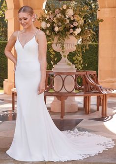 a woman in a white wedding dress posing for the camera with her hand on her hip