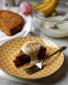 a piece of cake on a yellow and white plate with a fork next to it