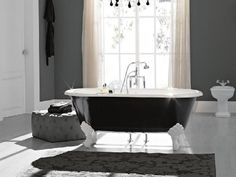 an old fashioned bathtub sits in front of a window