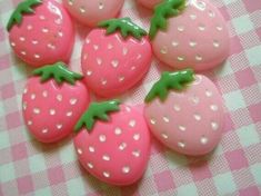 some pink and green strawberries on a checkered table cloth