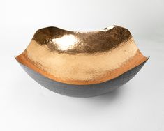 a large metal bowl sitting on top of a white table