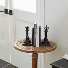 two bookends are sitting on a table next to a pair of black candlesticks