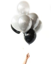 a woman is holding balloons in the air