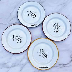 three plates with the letters p and s on them sitting on a marble counter top