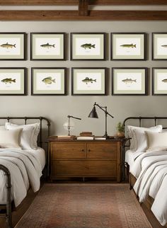 two twin beds in a bedroom with pictures on the wall above them and below them