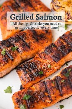 grilled salmon on a white plate with lemon wedges and parsley garnish