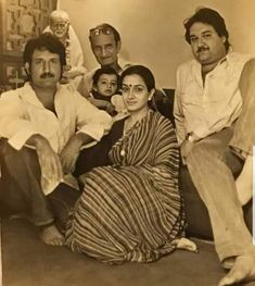 an old black and white photo of people sitting on a couch with one woman in the middle