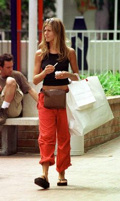 a woman walking down the street carrying shopping bags