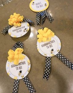 four badges that say grandmother to bee and are decorated with polka dot ribbon, yellow flowers and black dots