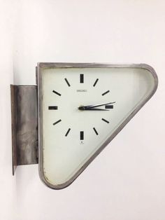 a clock mounted to the side of a wall with numbers on it's face