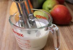 an image of a mixer with apples in the background