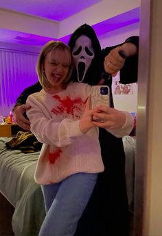 a woman taking a selfie with a creepy mask on