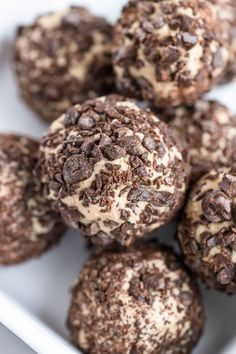 chocolate cookies with white frosting and sprinkles in a square plate on a table