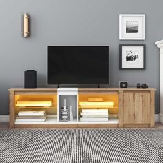 an entertainment center with a flat screen tv mounted on it's side, in front of a gray wall