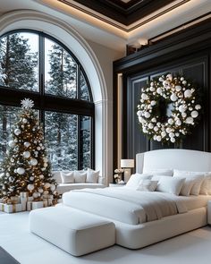 a white bed sitting under a large window next to a christmas tree