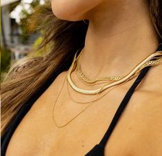 This necklace features a sleek snake chain design characterized by its smooth, fluid texture that drapes beautifully around the neck. Crafted from high-quality gold, it is engineered to resist water and tarnish, ensuring a lasting shine and impeccable appearance through life's adventures. Whether worn alone for a chic minimalist look or layered with other pieces for added depth, this necklace epitomizes versatile luxury. This snake chain necklace is a timeless addition to any jewelry collection, Multiple Necklaces, Tennis Sunglasses, Brazilian Gold, Gold Water, Flip Flop Shoes, Gold Filled Jewelry, Cozy Fashion, Gold Filled Chain, Boutique Jewelry